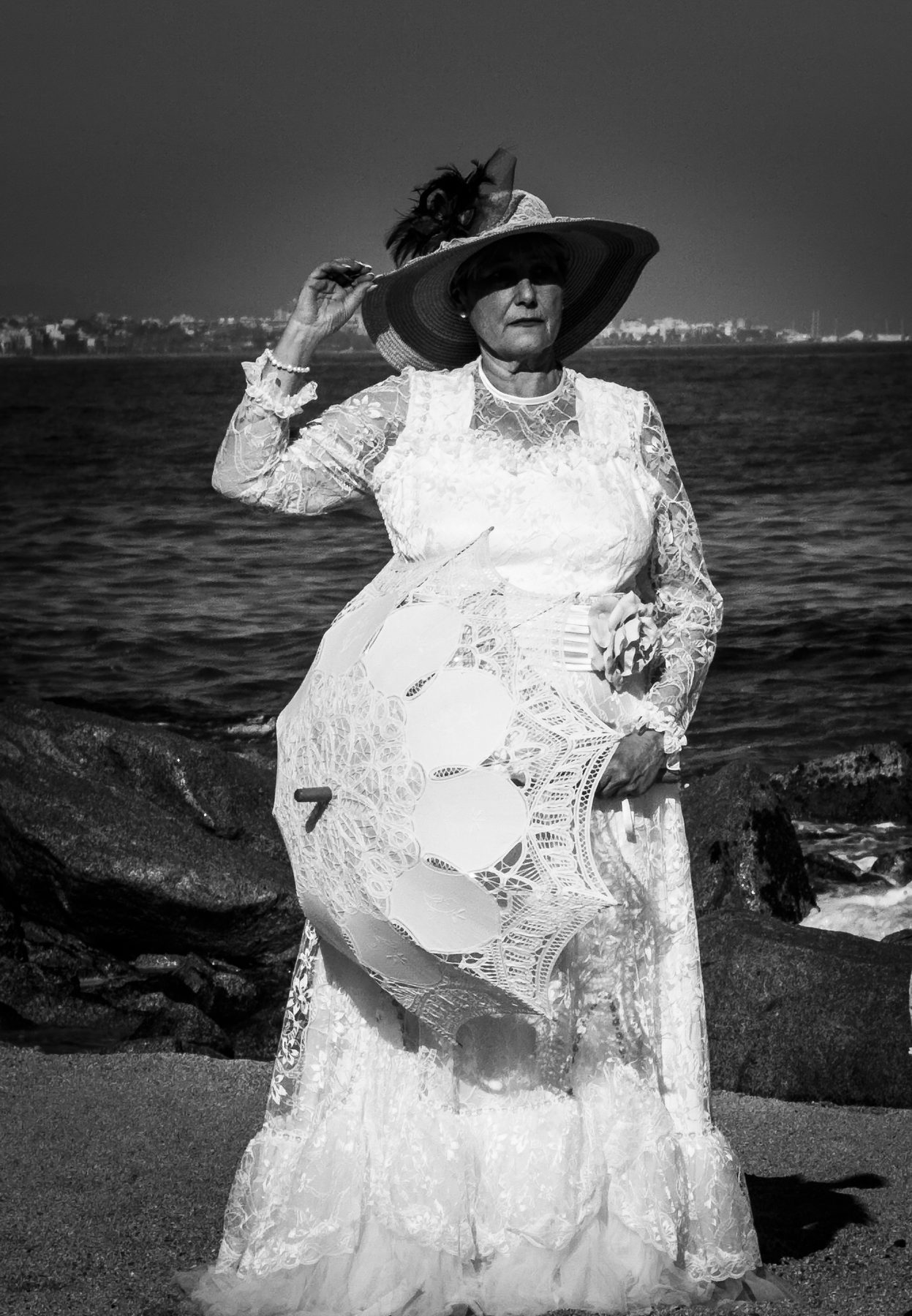 La bisabuela de alguien — retrato de una mujer con vestido y sombrero de época, frente al mar