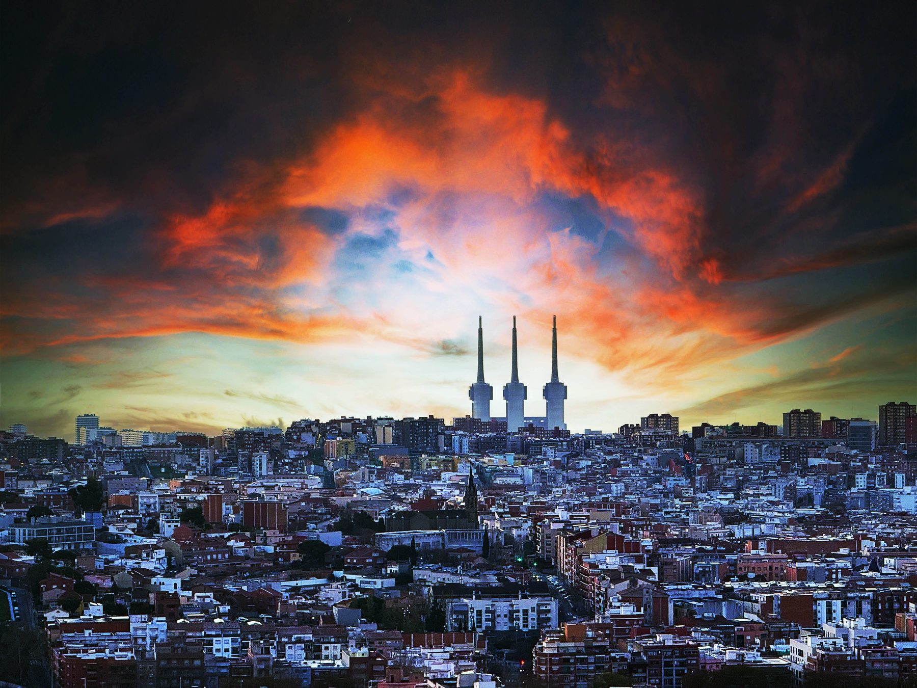 Ciudad — un cielo dramático de atardecer sobre el perfil de la ciudad, con las Tres Xemeneies de Sant Adrià del Besòs