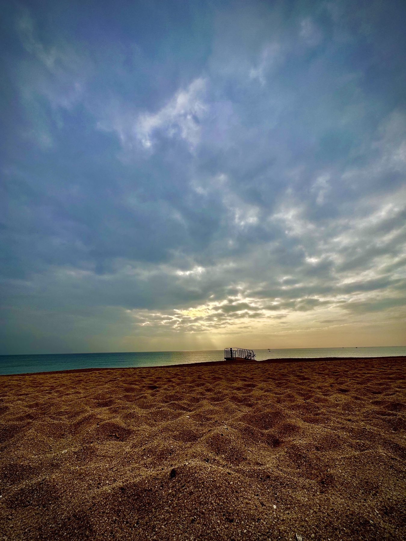 Playa vacía — Arena en primer plano y un cielo amplio y nublado sobre el mar