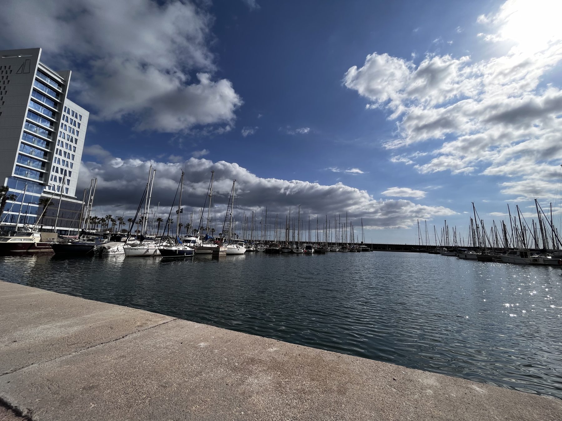 Mástiles — Puerto deportivo con veleros amarrados y cielo azul con nubes