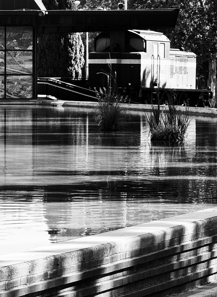 Reposo — locomotora y su reflejo en el agua, en blanco y negro